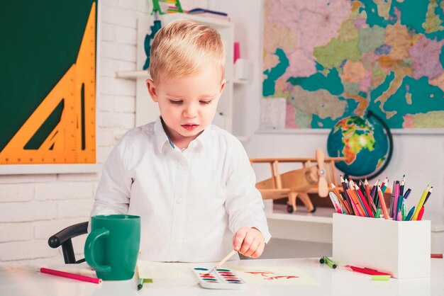 Happy school kids at lesson kid gets ready for school cute pupil with funny face schooling work educ