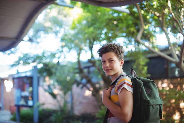 Photo happy schoolboy standing in school campus