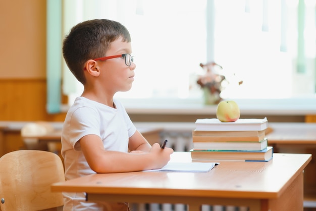 机、教室に座っている幸せな男子生徒