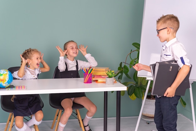 幸せな小学生の男の子と女の子が一緒に学校で勉強します