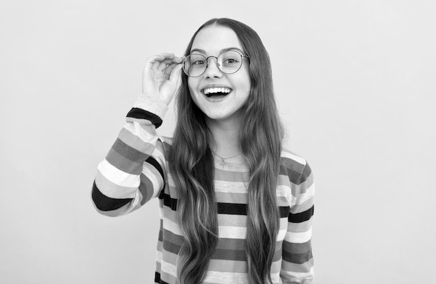 Happy schoolgirl nerd kid in eyeglasses for vision eyesight