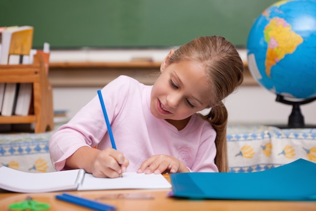 Happy schoolgirl writing