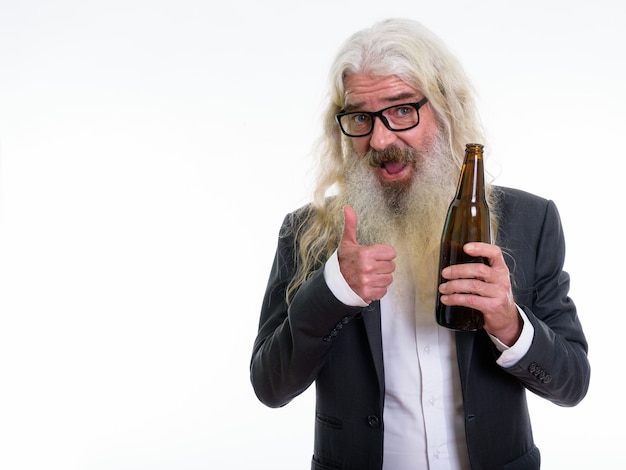 happy senior bearded businessman smiling while holding bottle of beer