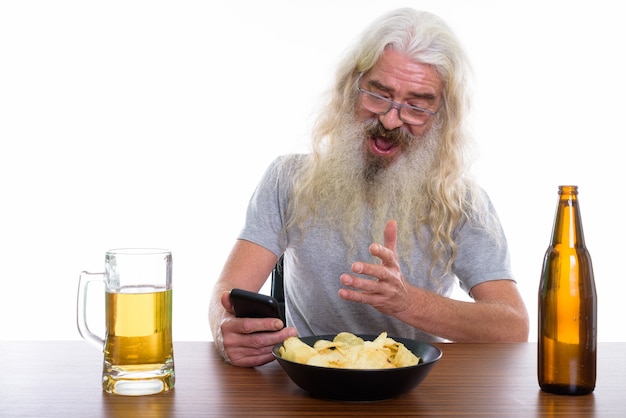 happy senior bearded man smiling while using mobile