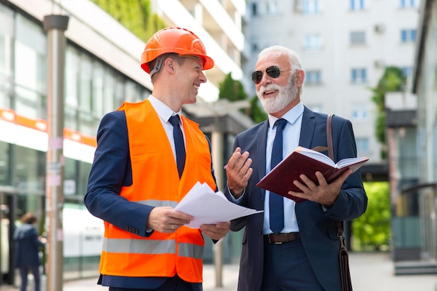 Happy senior business man talking with young engineer man