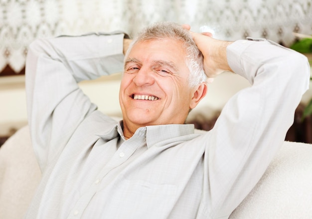 Happy senior businessman relaxing at home after work