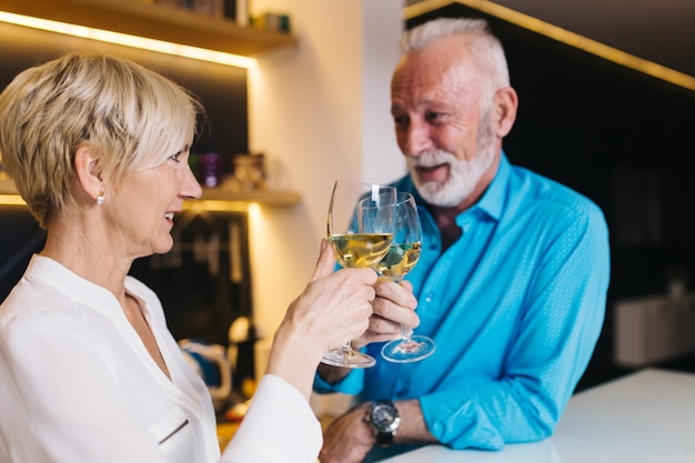 Happy senior couple celebrating anniversary and drinking wine.