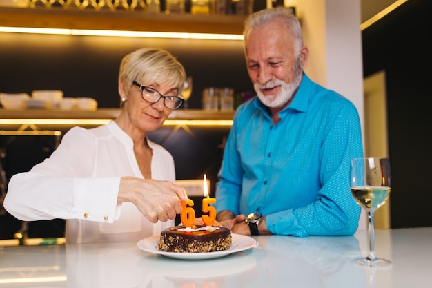 一緒に誕生日を祝う幸せな年配のカップル。