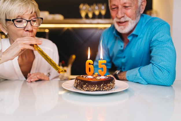 一緒に誕生日を祝う幸せな年配のカップル。