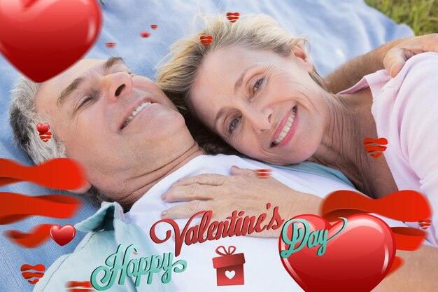 Happy senior couple cuddling on blanket against cute valentines message