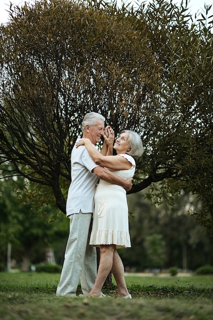 Happy senior couple dancing in autumn forest