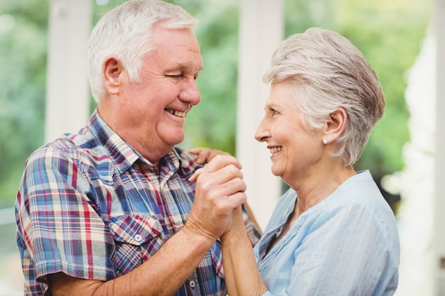 Coppie senior felici che ballano a casa