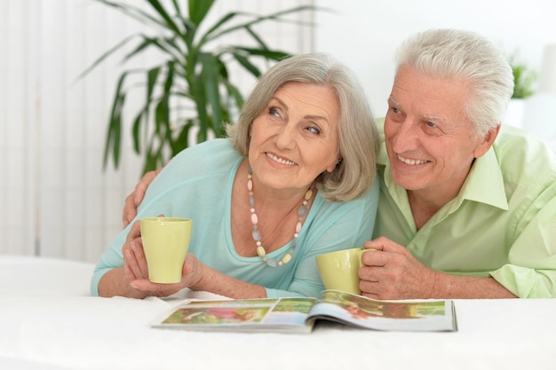 Happy Senior couple drinking tea  and reading magazine