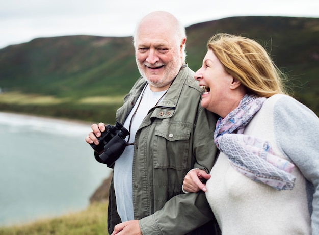 Happy senior couple enjoying with a pair of binoculars