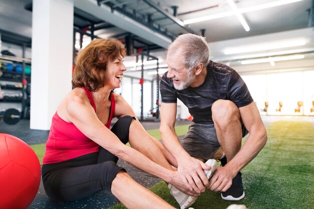 Happy senior couple exercising in gym