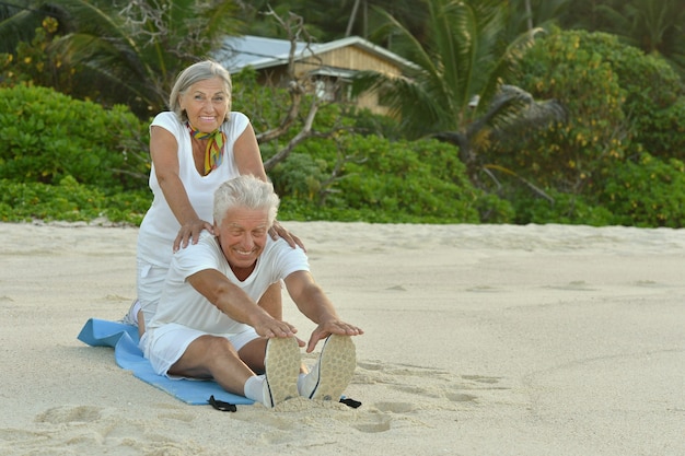 Happy Senior couple exercising in summer on  seashore