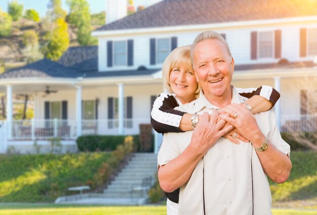 Happy Senior Couple in Front Yard of House