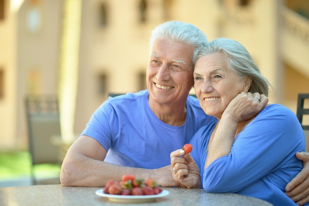 Happy Senior couple having breakfast in cafe with strawberries