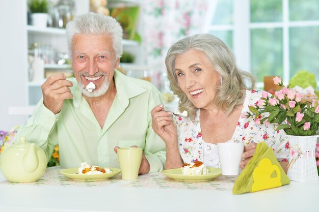 Счастливая пожилая пара вместе завтракает на кухне