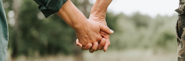 Happy senior couple holding hands hands of man and woman hold each other romance and love and support in elderly family faceless husband and wife travel together in nature countryside life banner