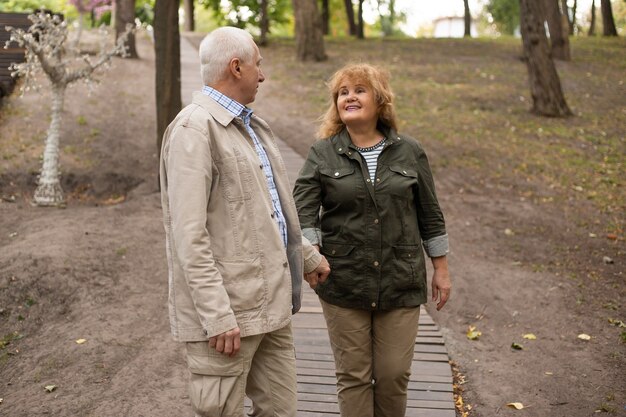 写真 秋の自然の中を散歩するのが大好きな幸せな年配のカップル、春の時間にリラックスした年配のカップル。
