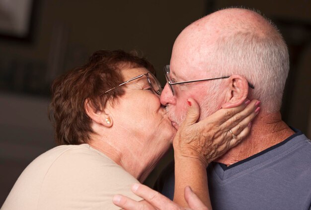 幸せな年配のカップルがキスをしている