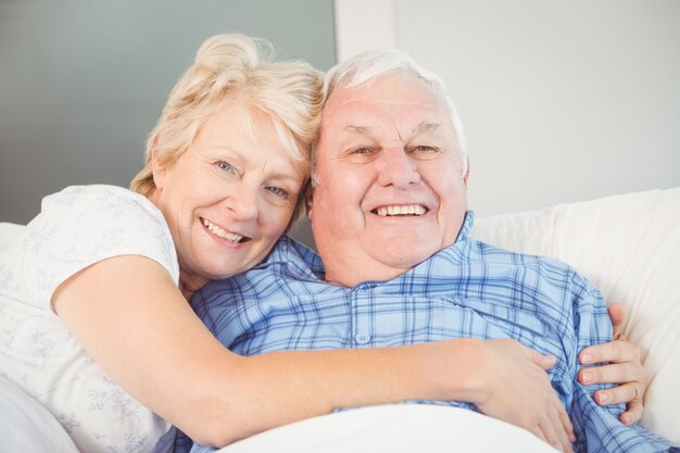 Happy senior couple lying on bed