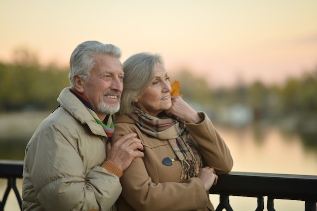 Happy senior couple  near river at autumn