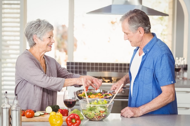 happy senior couple preparing food