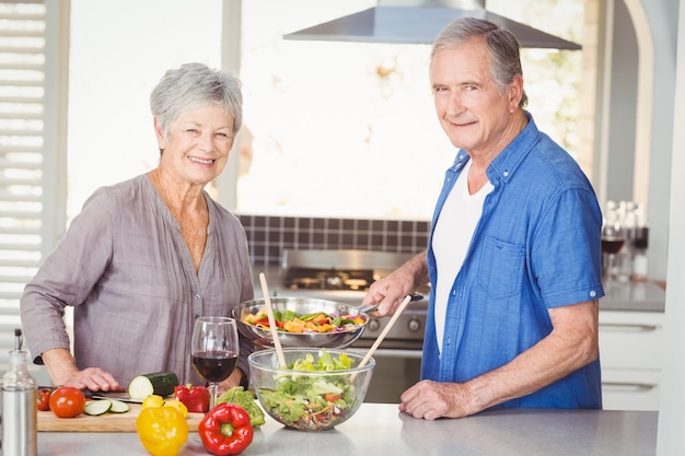 happy senior couple preparing food