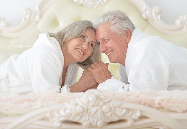 Happy Senior couple reading in a bed