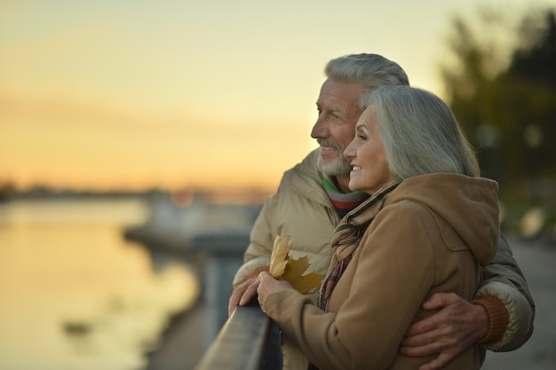 Photo happy senior couple relax in autumn park near river