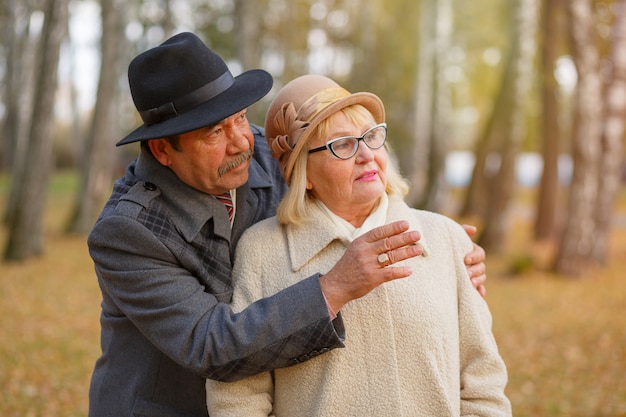 Happy senior couple relaxing in autumn forest