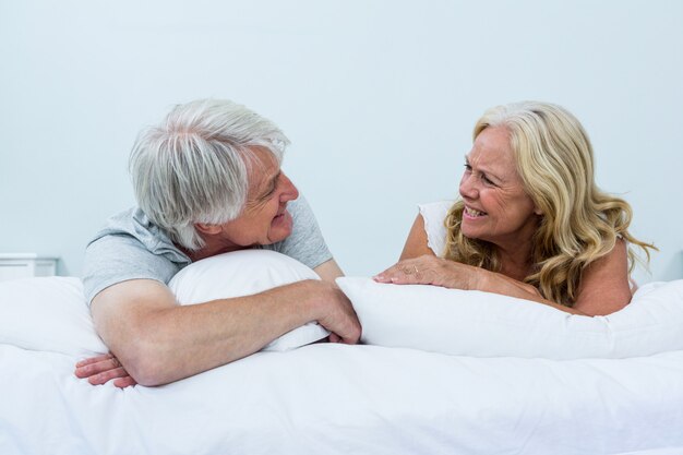 Happy senior couple relaxing on bed