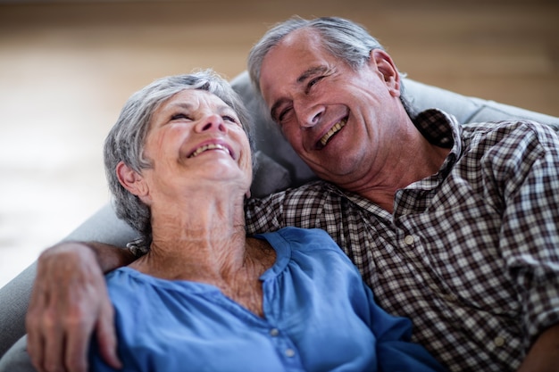 Happy senior couple relaxing on sofa and smiling