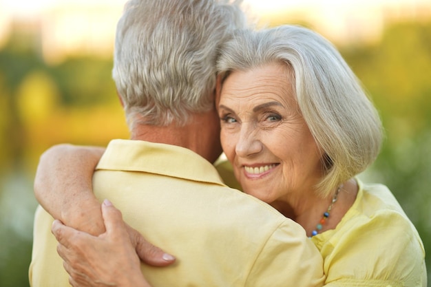 Happy senior couple smiling and hugging outdoors