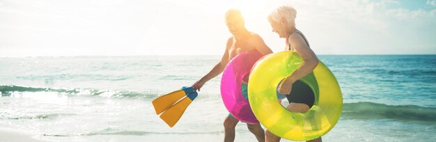 Happy senior couple walking on beach