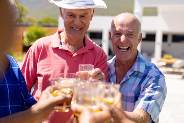 Happy senior diverse people making toast and smiling in garden