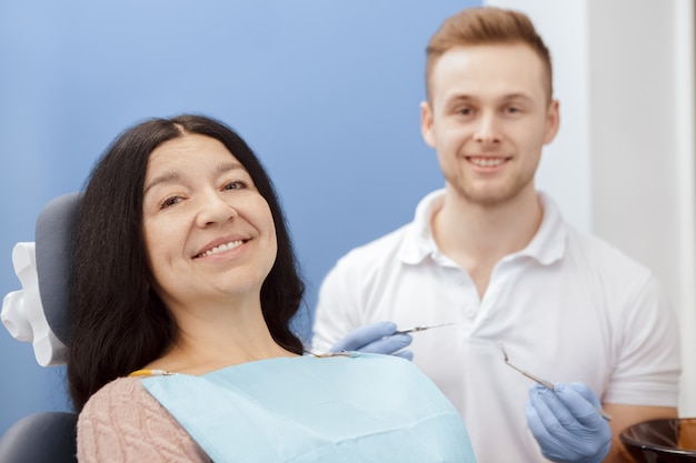 Happy senior female patient at the dentist appointment 