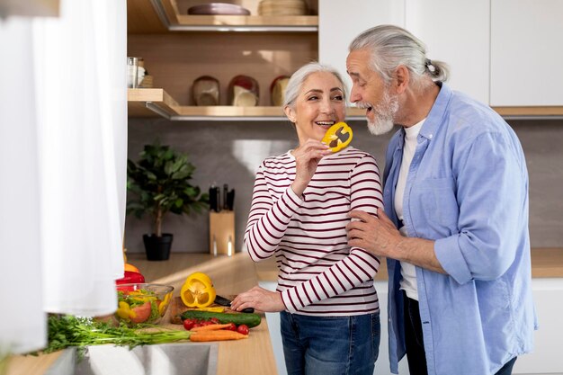 Happy Senior Husband And Wife Cooking Lunch And Having Fun In Kitchen