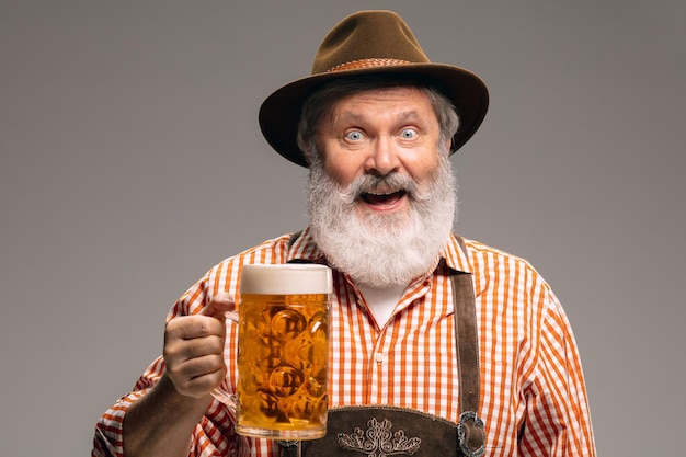 Happy senior man dressed in traditional Austrian or Bavarian costume gesturing