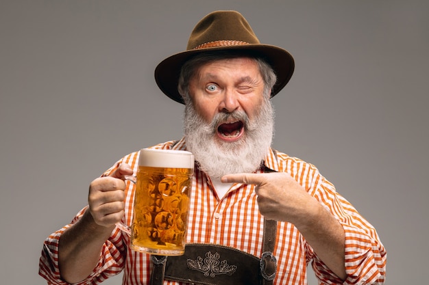 Happy senior man dressed in traditional Austrian or Bavarian costume gesturing