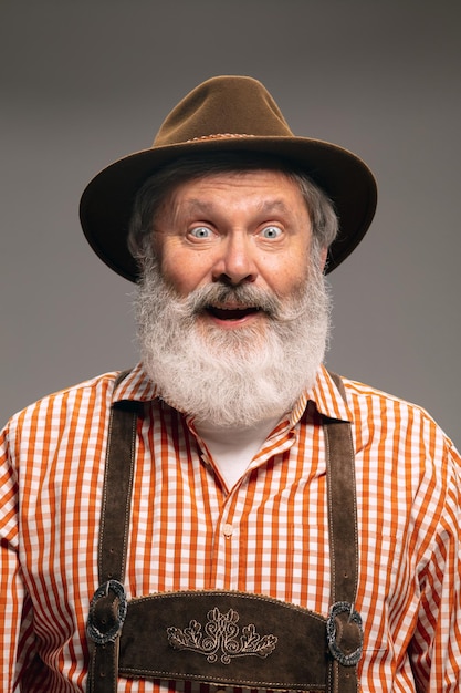 Happy senior man dressed in traditional austrian or bavarian costume gesturing