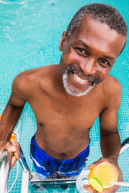 Happy senior man having party in the swimming pool