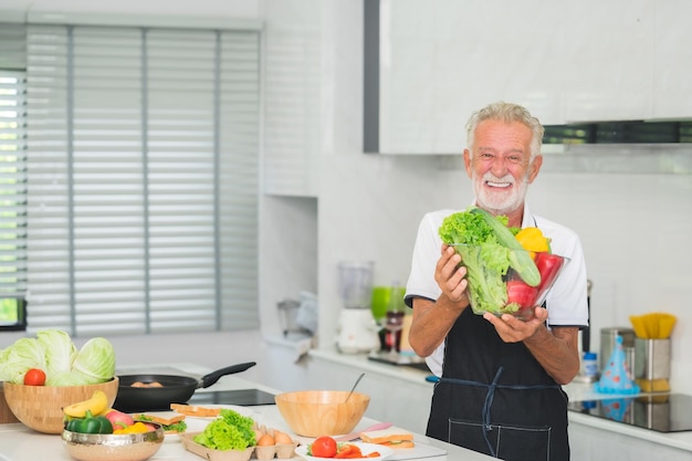 Photo happy senior man in kitchen