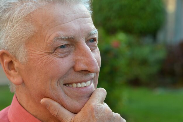 Happy senior man on a walk in the park in summer