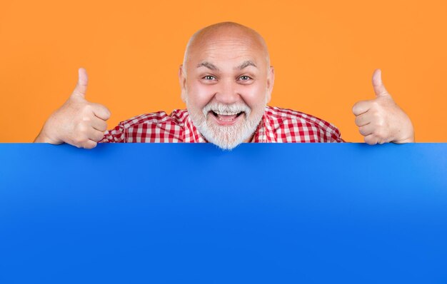 Happy senior man with copy space on blank banner advertisement thumb up