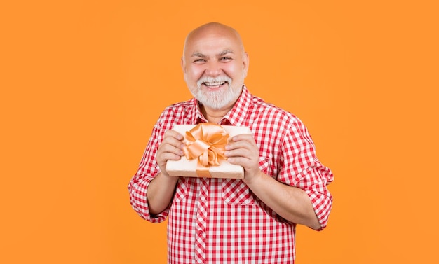 Happy senior man with present box for anniversary