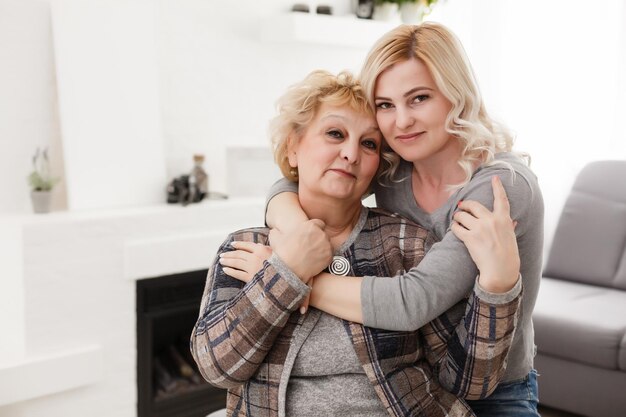 happy senior mother and adult daughter closeup portrait at home