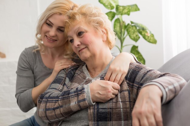 happy senior mother and adult daughter closeup portrait at home